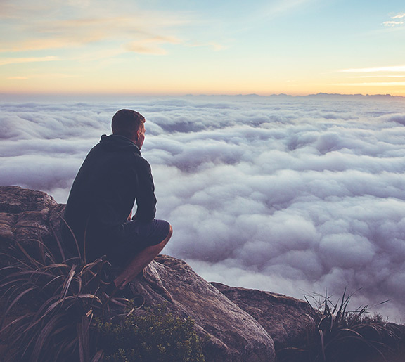 Stock photo showing someone looking down on a sea of clouds